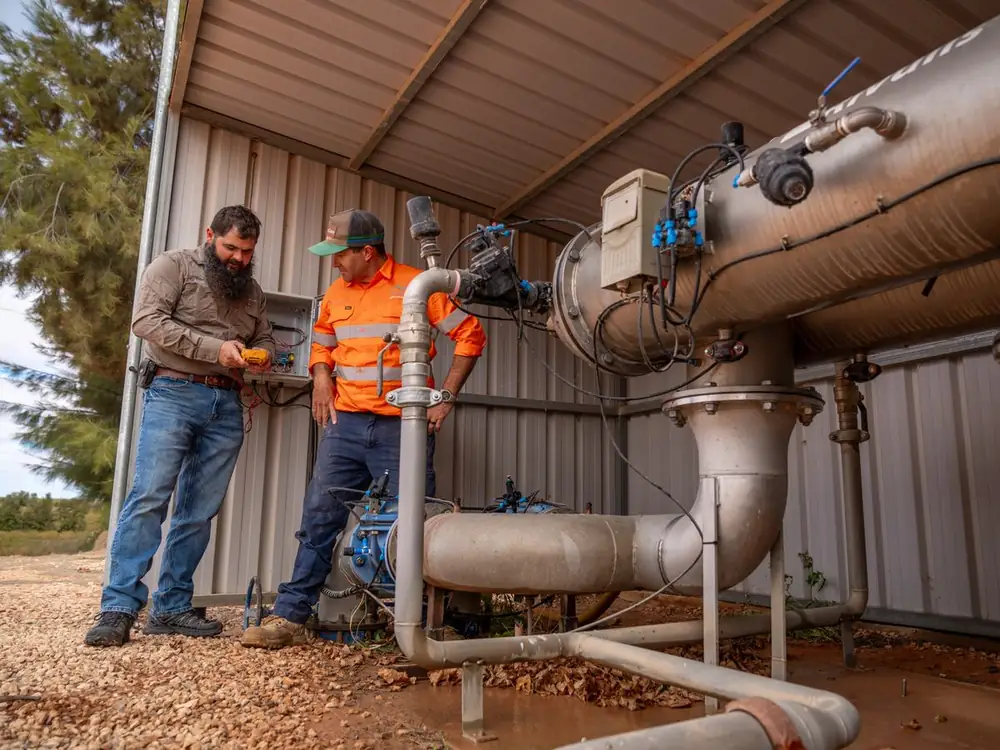 Two Ardal technicians checking a filtration station in a pump shed