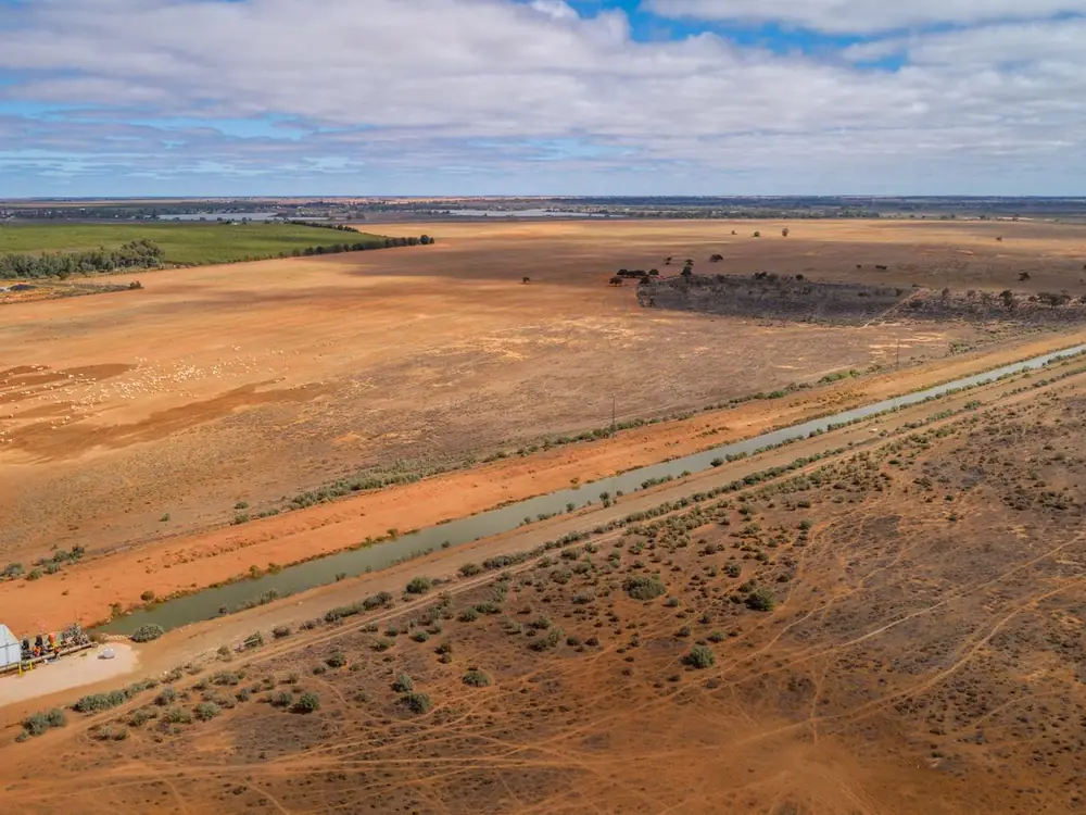 Aerial view of an irrigation channel across flat farmland