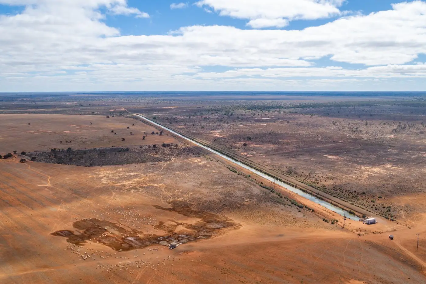 Aerial view of cleared farmland beside an irrigation channel