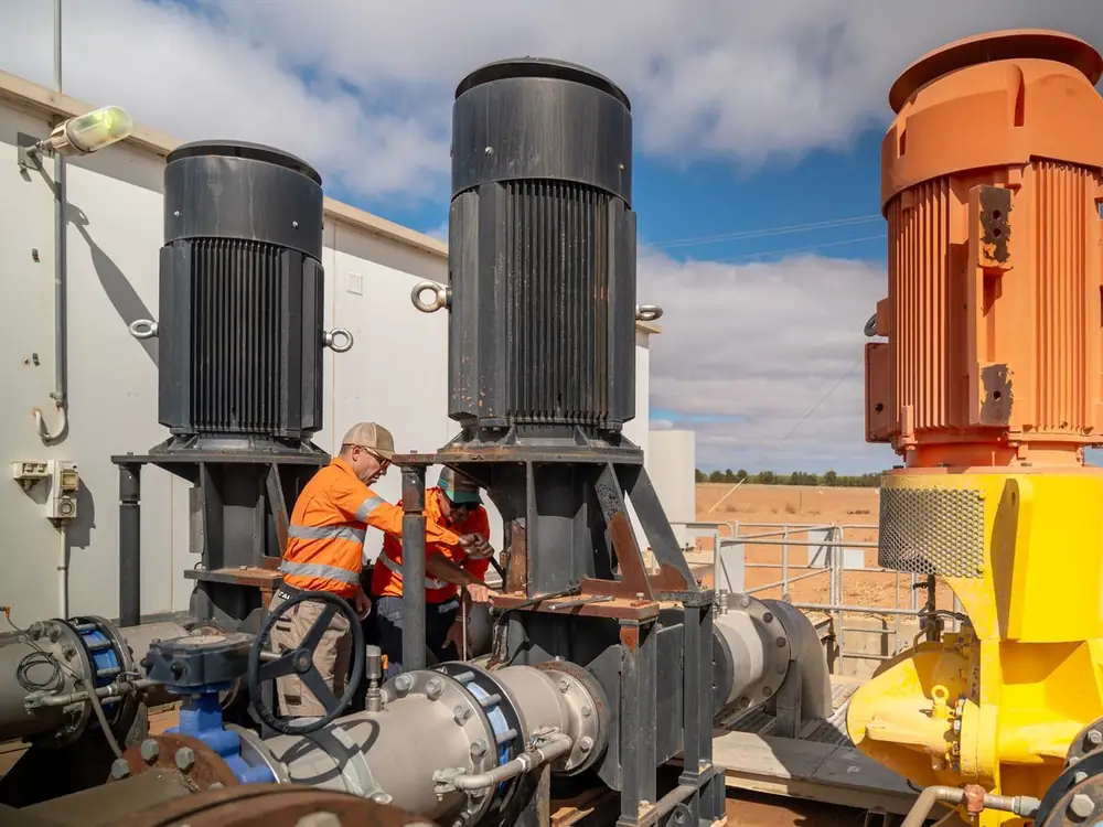Ardal technicians working between large pump motors at a pump station