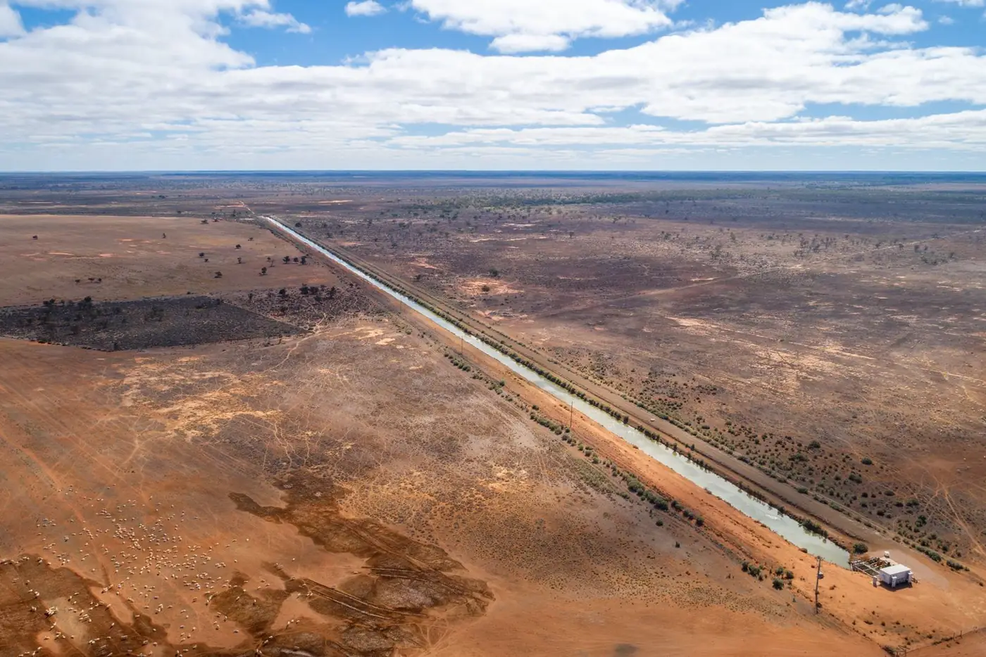 Aerial view of an irrigation channel running straight across open country