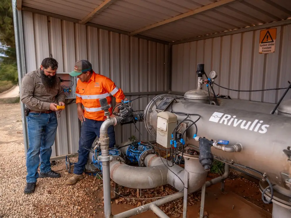 Two Ardal technicians checking a filtration station with a multimeter
