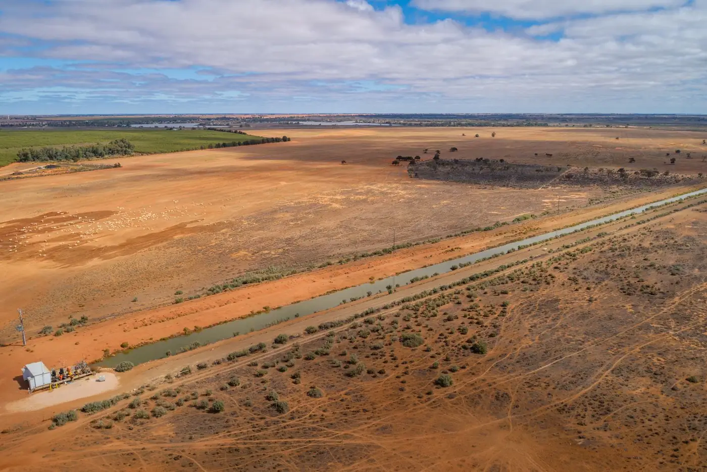 Aerial view of an irrigation channel across flat farmland