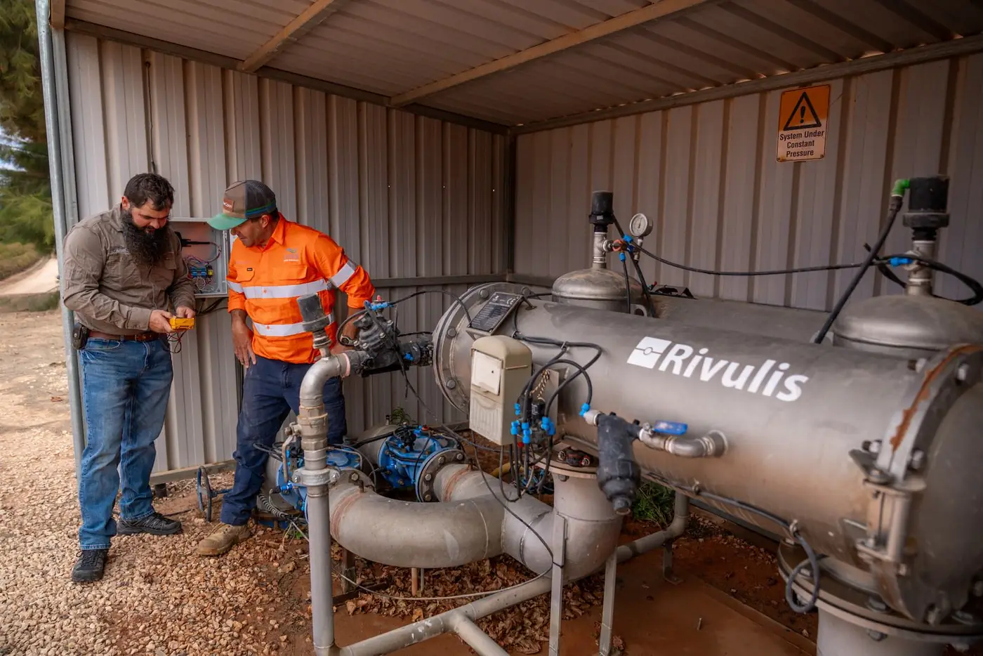Two Ardal technicians checking a filtration station with a multimeter