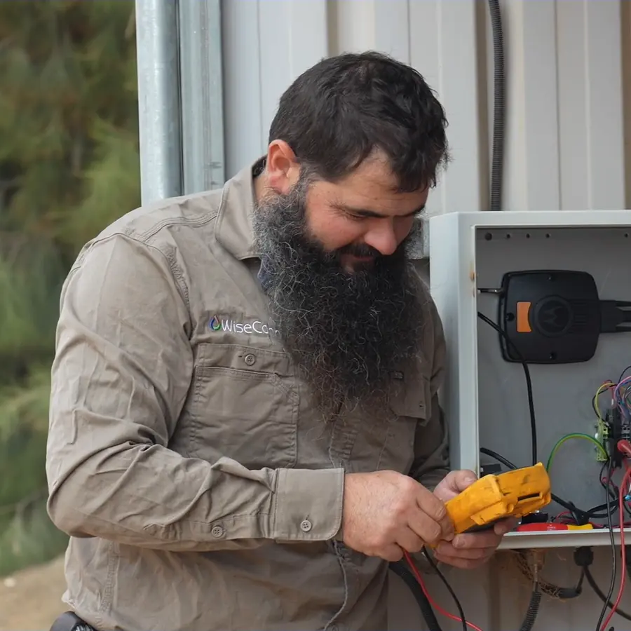 Field technician testing a controller with a multimeter, from Ardal's technical services video